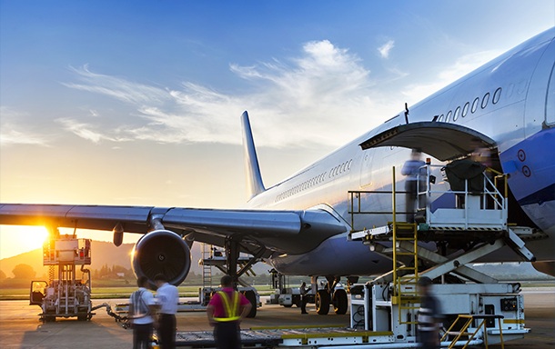 plane on runway preparing for shipping out cargo at sunset