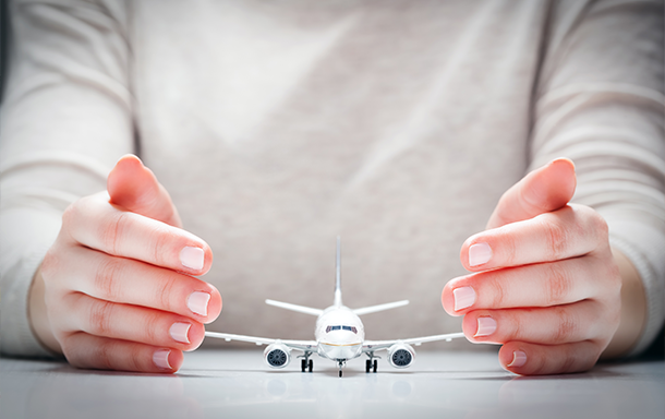 hands presenting a miniature airplane figurine