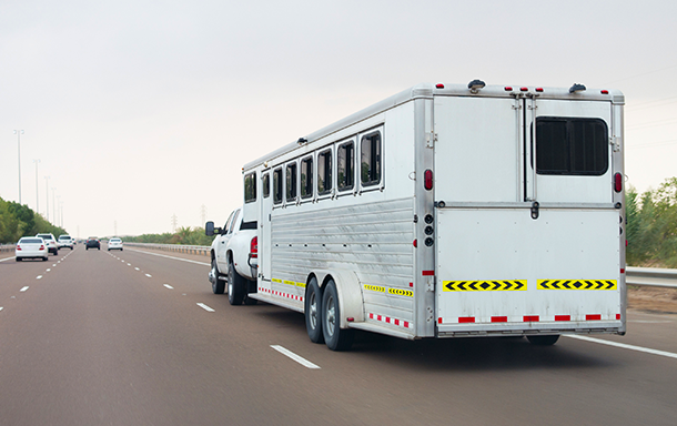 animal trailer attachment on truck hauling animals on the highway