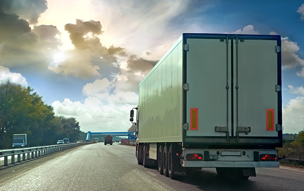 back of a semi truck transporting goods on an interstate highway