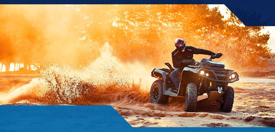 A man wearing a helmet rides an ATV