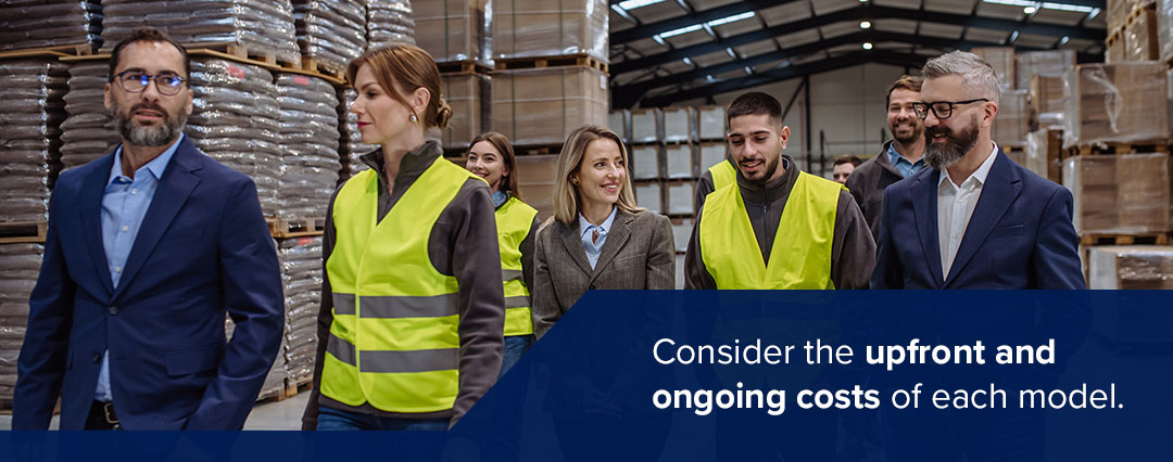 People in suits and warehouse works walkthrough a warehouse together