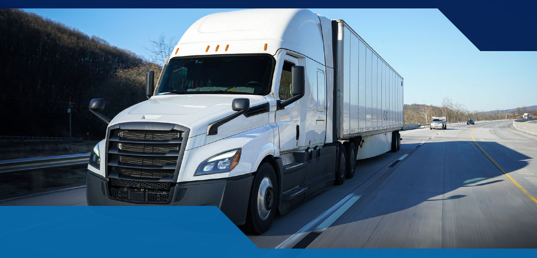 A white semi truck drives down a highway