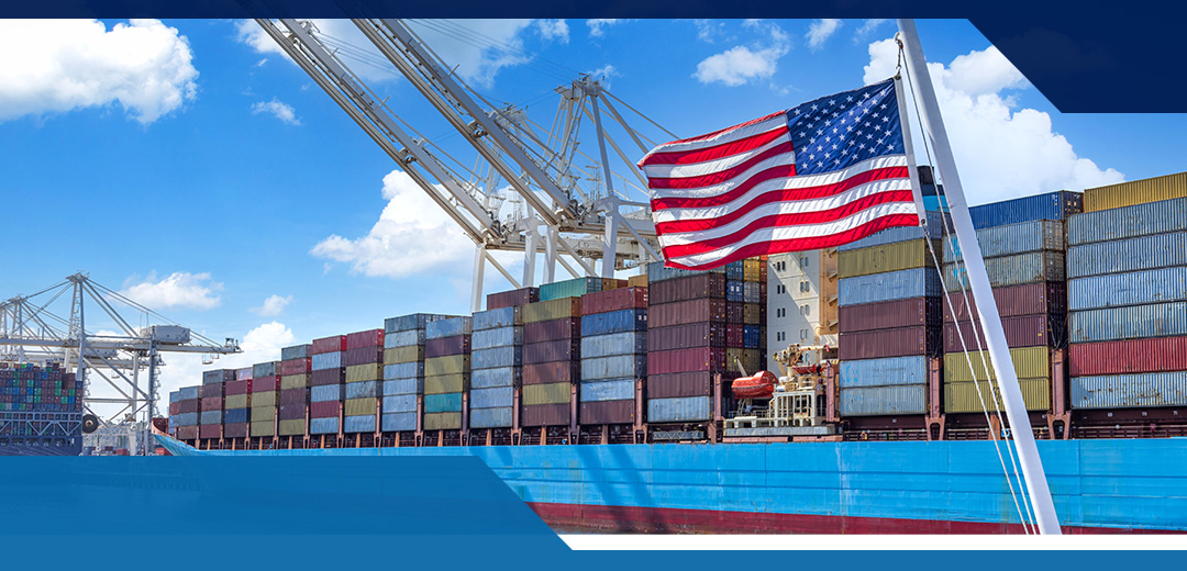 An American flag waves in front of a cargo ship